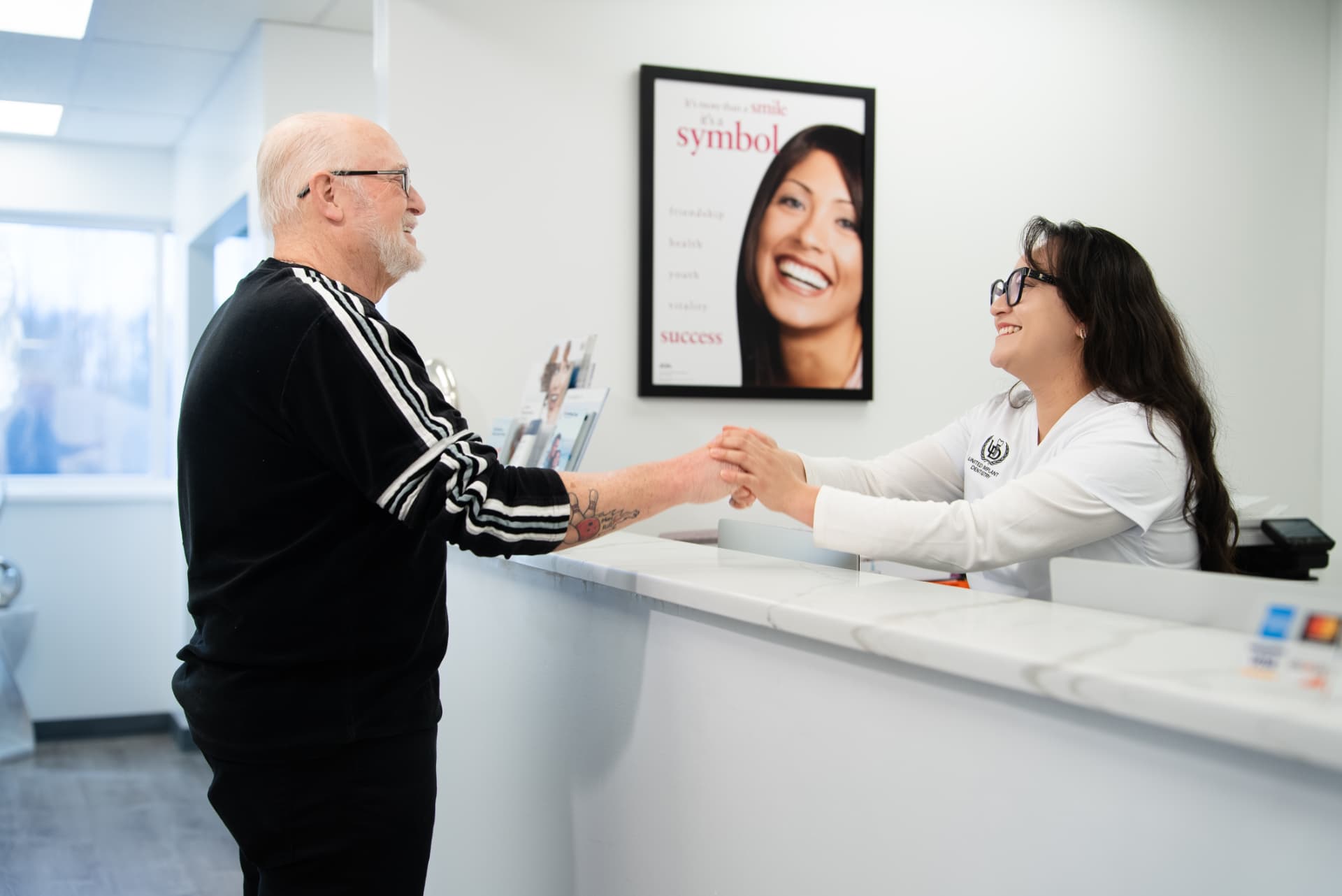 Patient greeted at the front desk of United Implant Dentistry in Cicero, NY