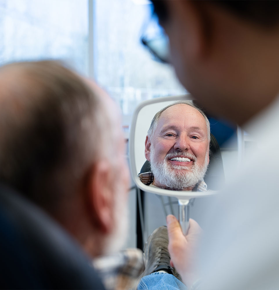 patient smiling into mirror
