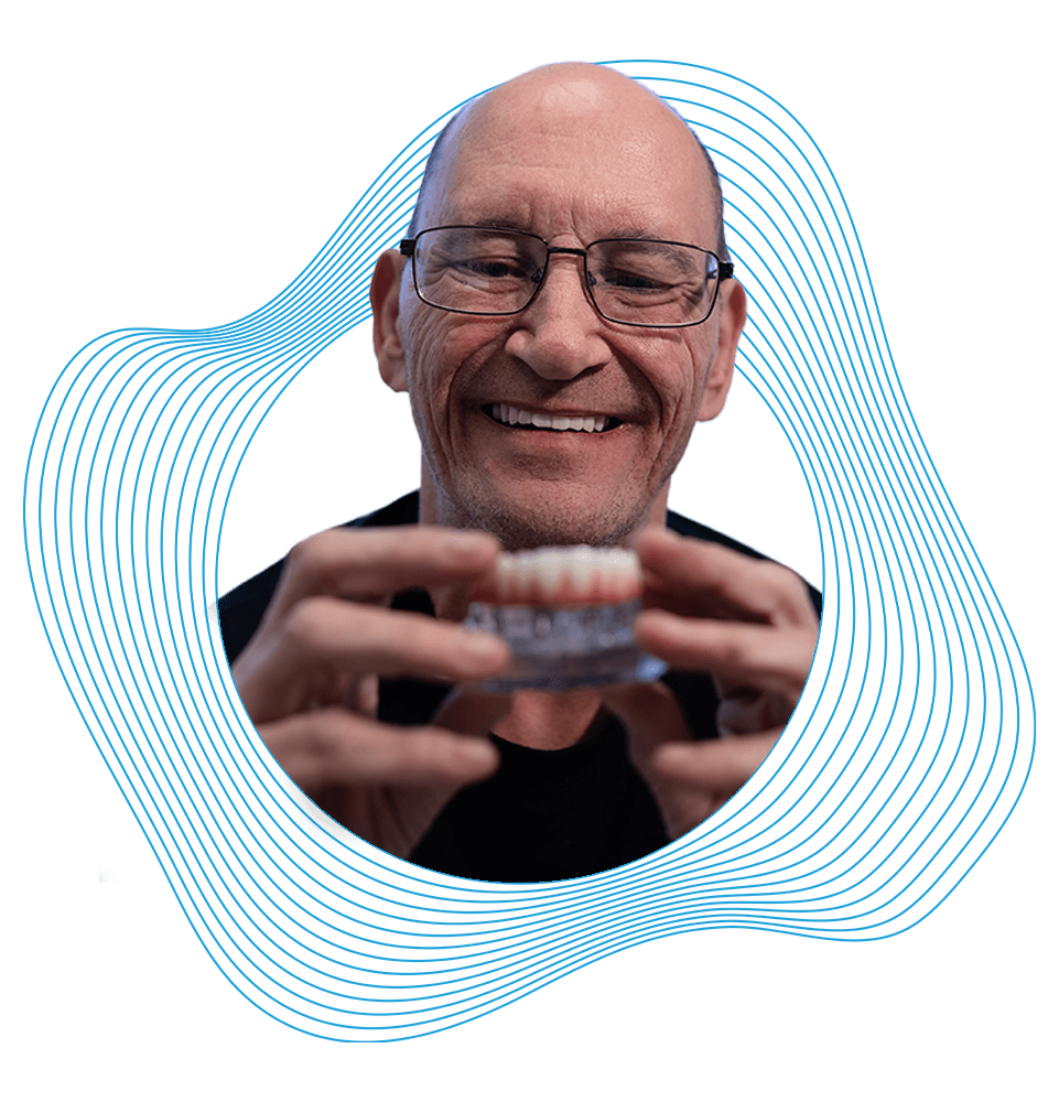 Patient looking at model of dental implants