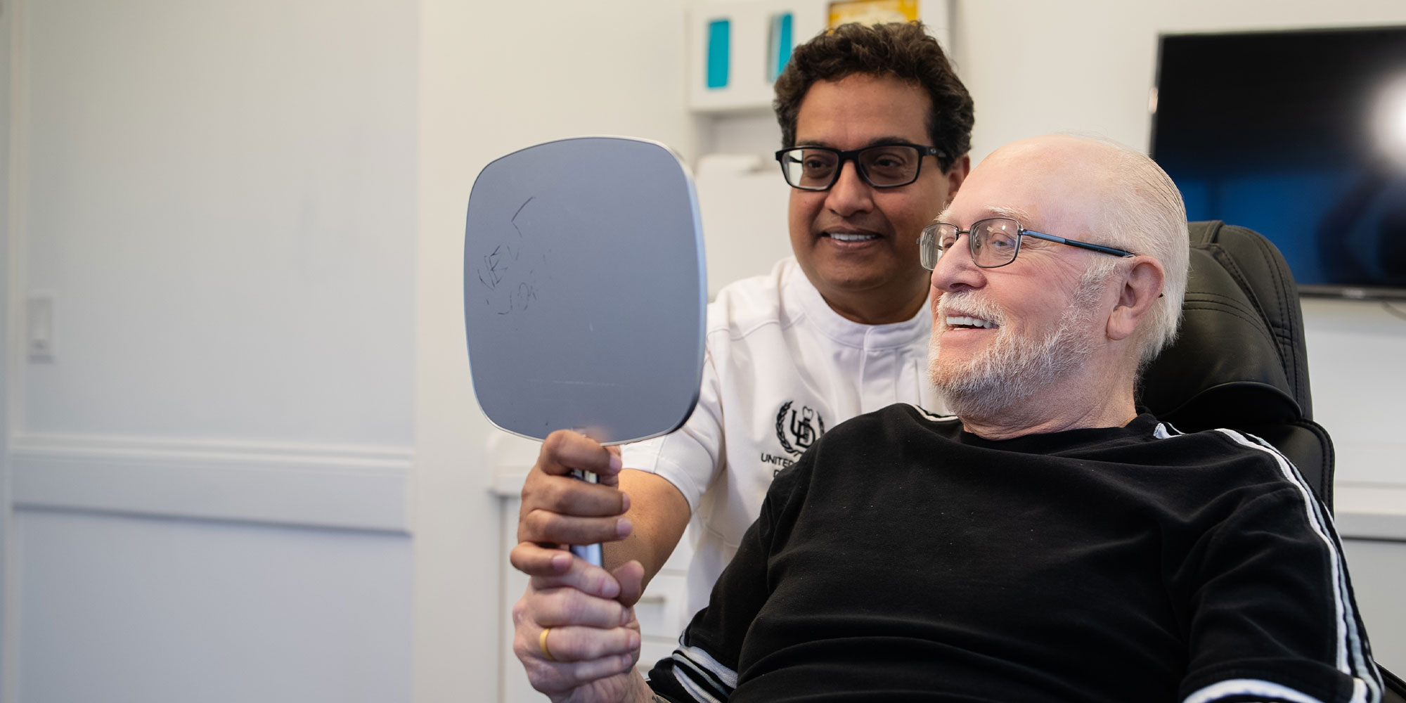 Dentist and patient looking into mirror